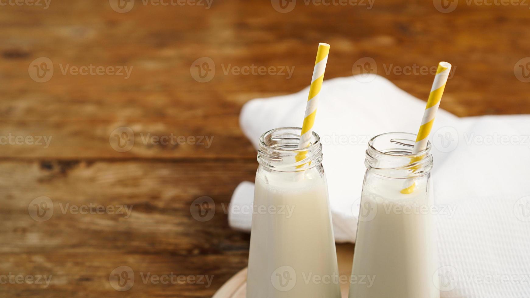 twee flessen biologische rustieke melk op houten tafel foto