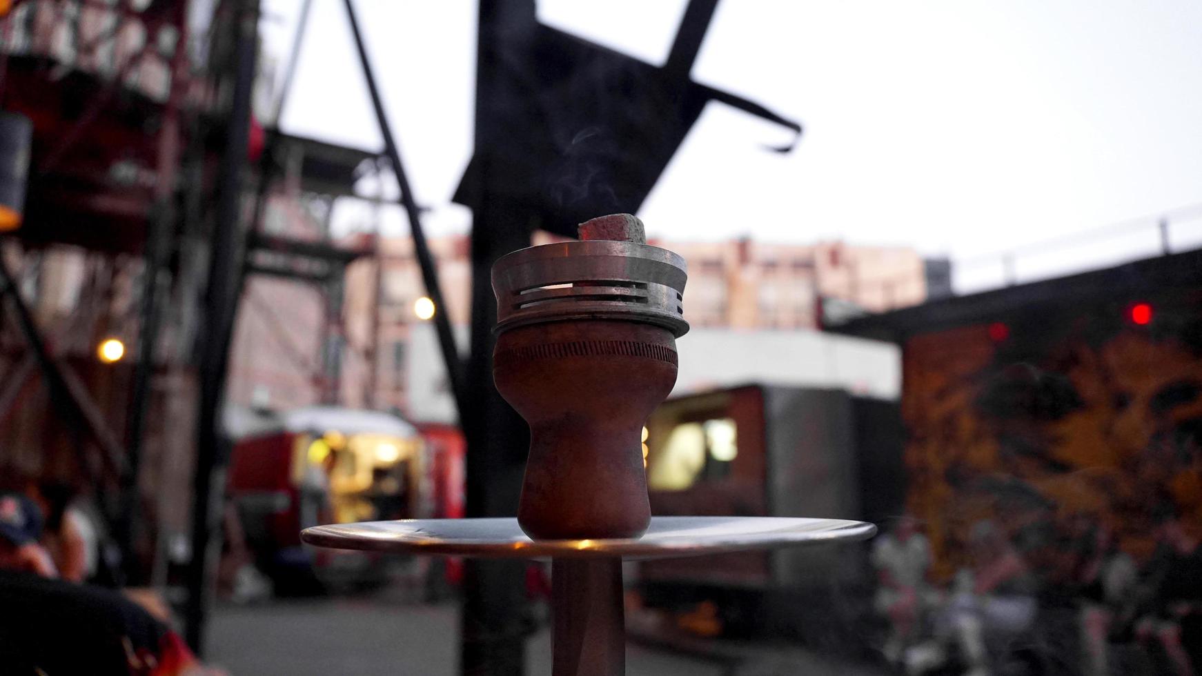 close-up van een waterpijpkom met houtskool. waterpijp bar buiten. foto