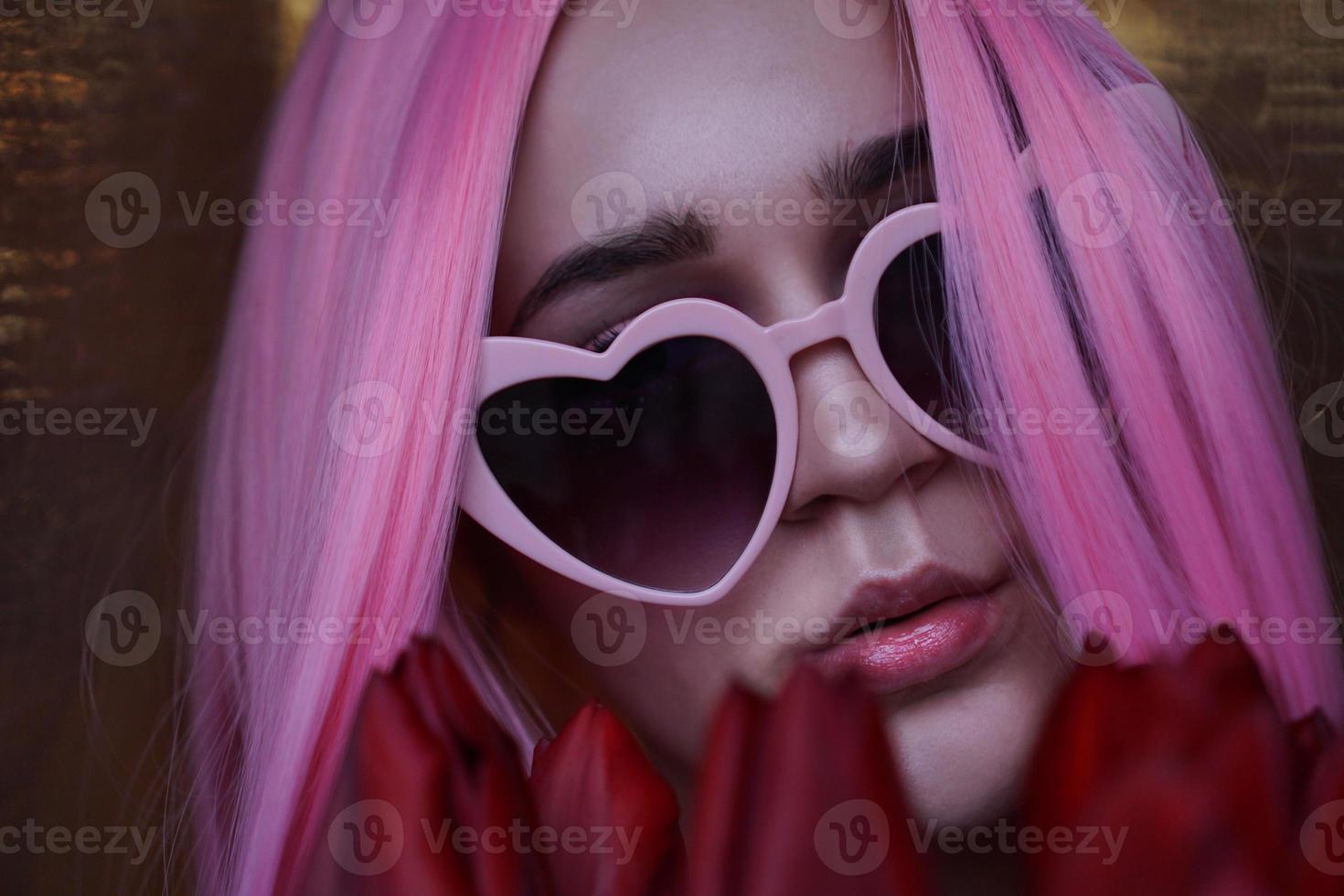 vrouw met tulpenbloemen - roze haar en hartvormige bril foto