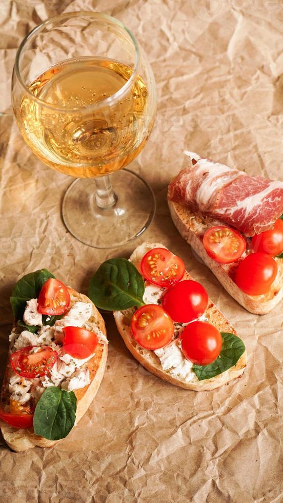 bruschetta met kerstomaatjes. wijnglas, Italiaans voorgerecht. foto