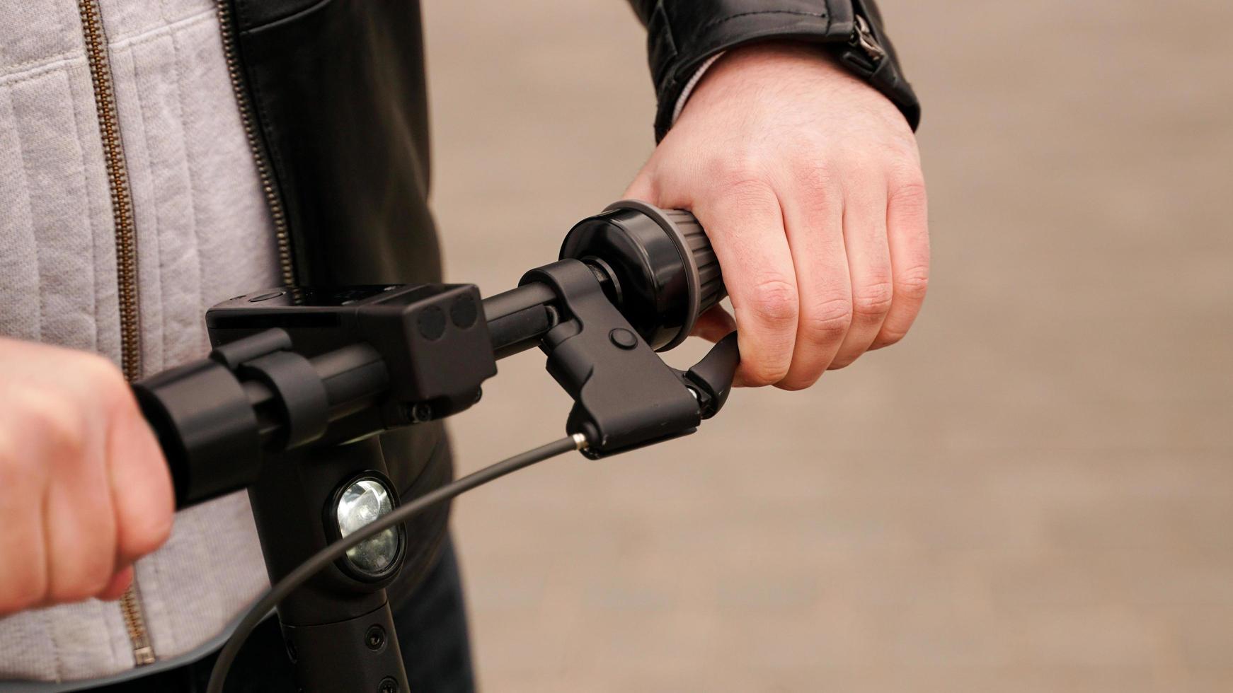 elektrisch scooterstuur en mannenhand op de hendel foto