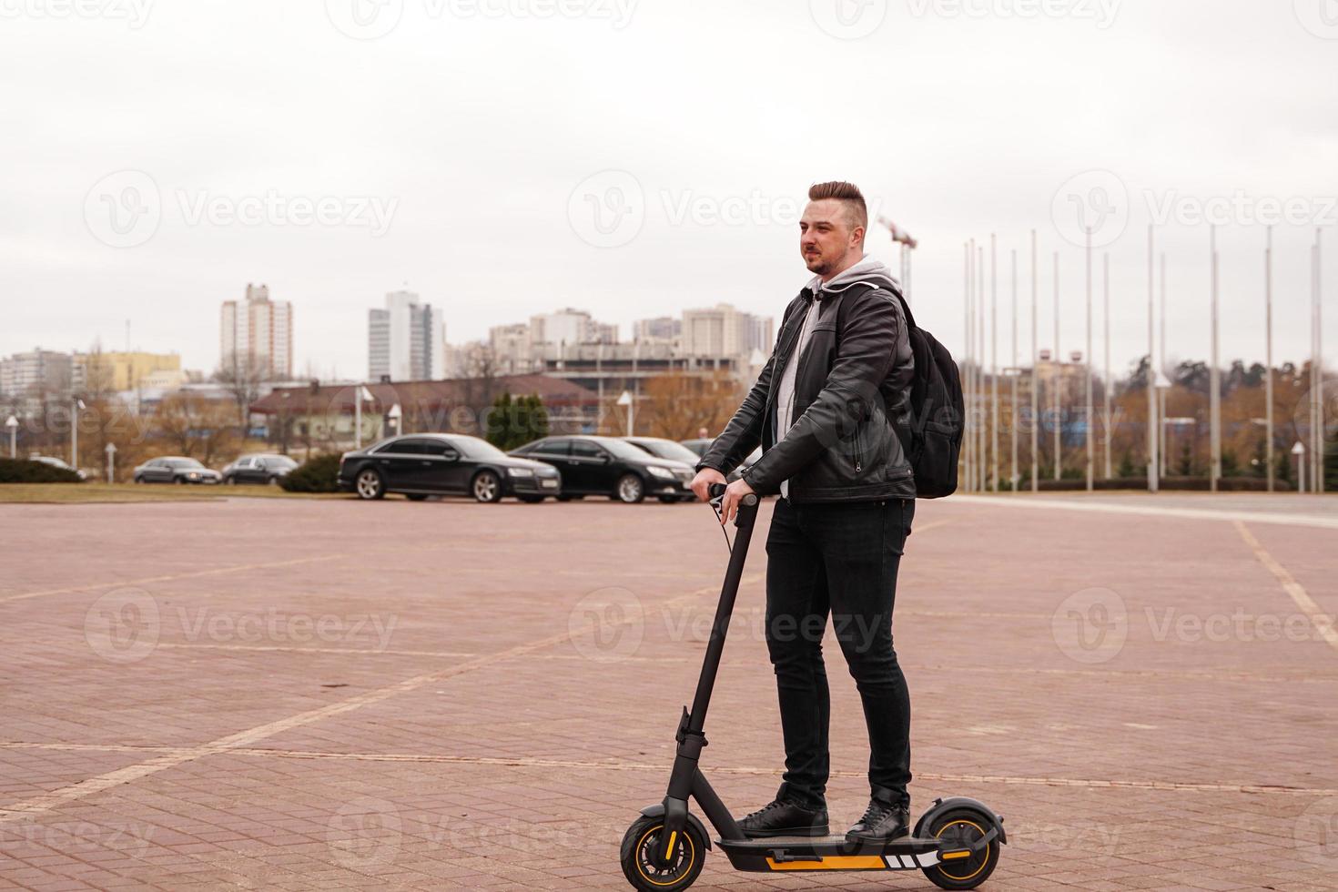 moderne man rijdt op een elektrische scooter in de stad foto