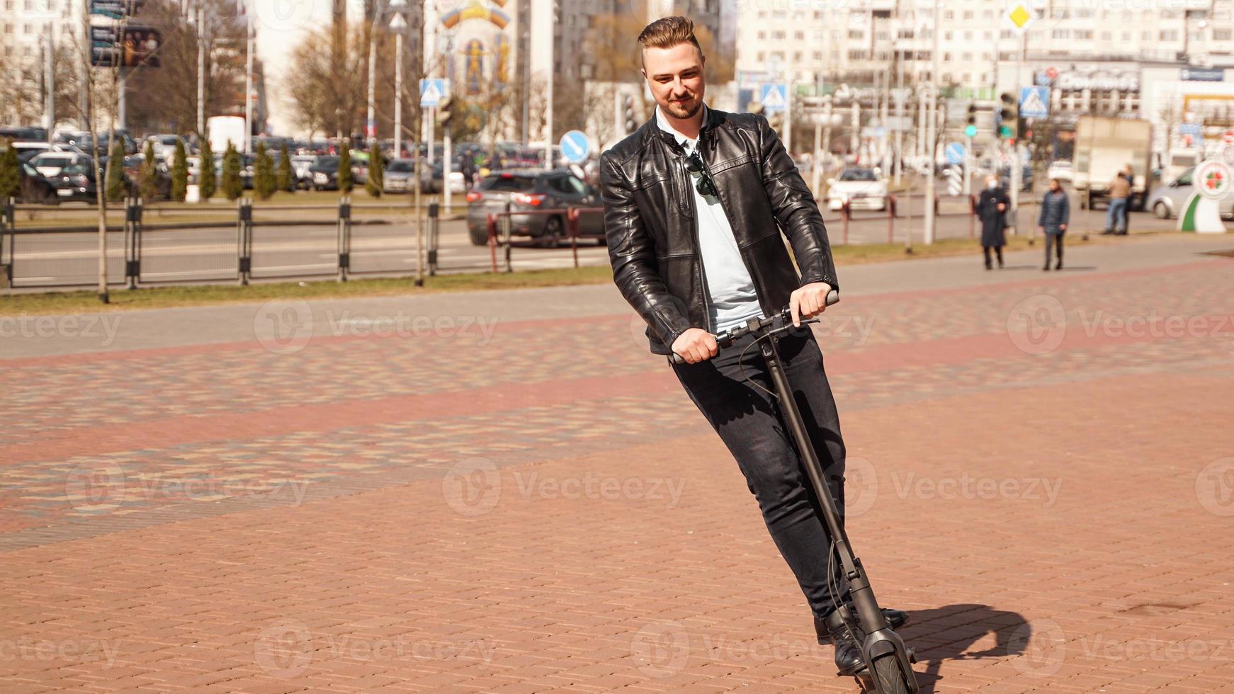 moderne man rijdt op een elektrische scooter in de stad foto