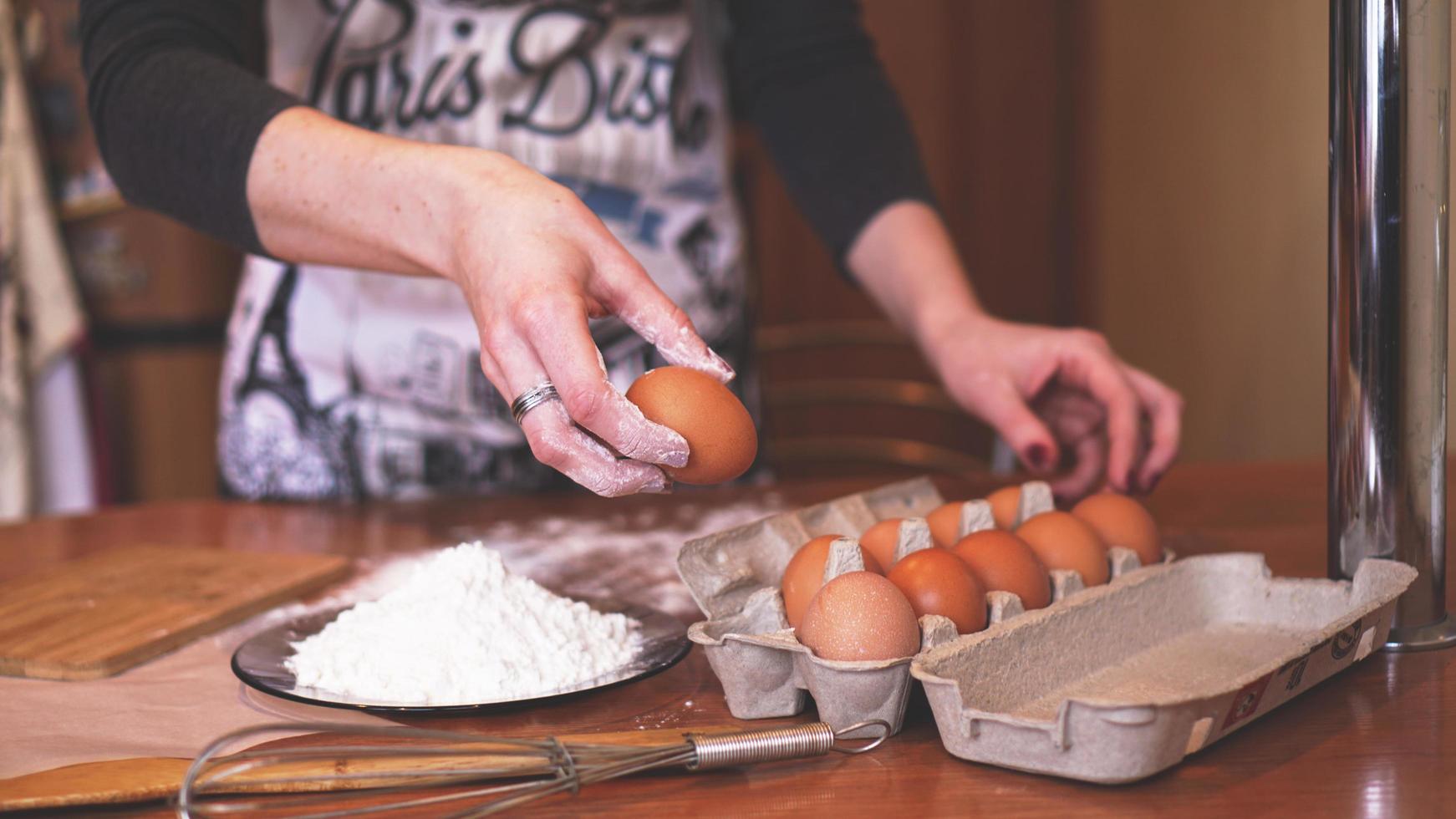 de handen van een vrouwelijke chef-kok die een ei plukt foto
