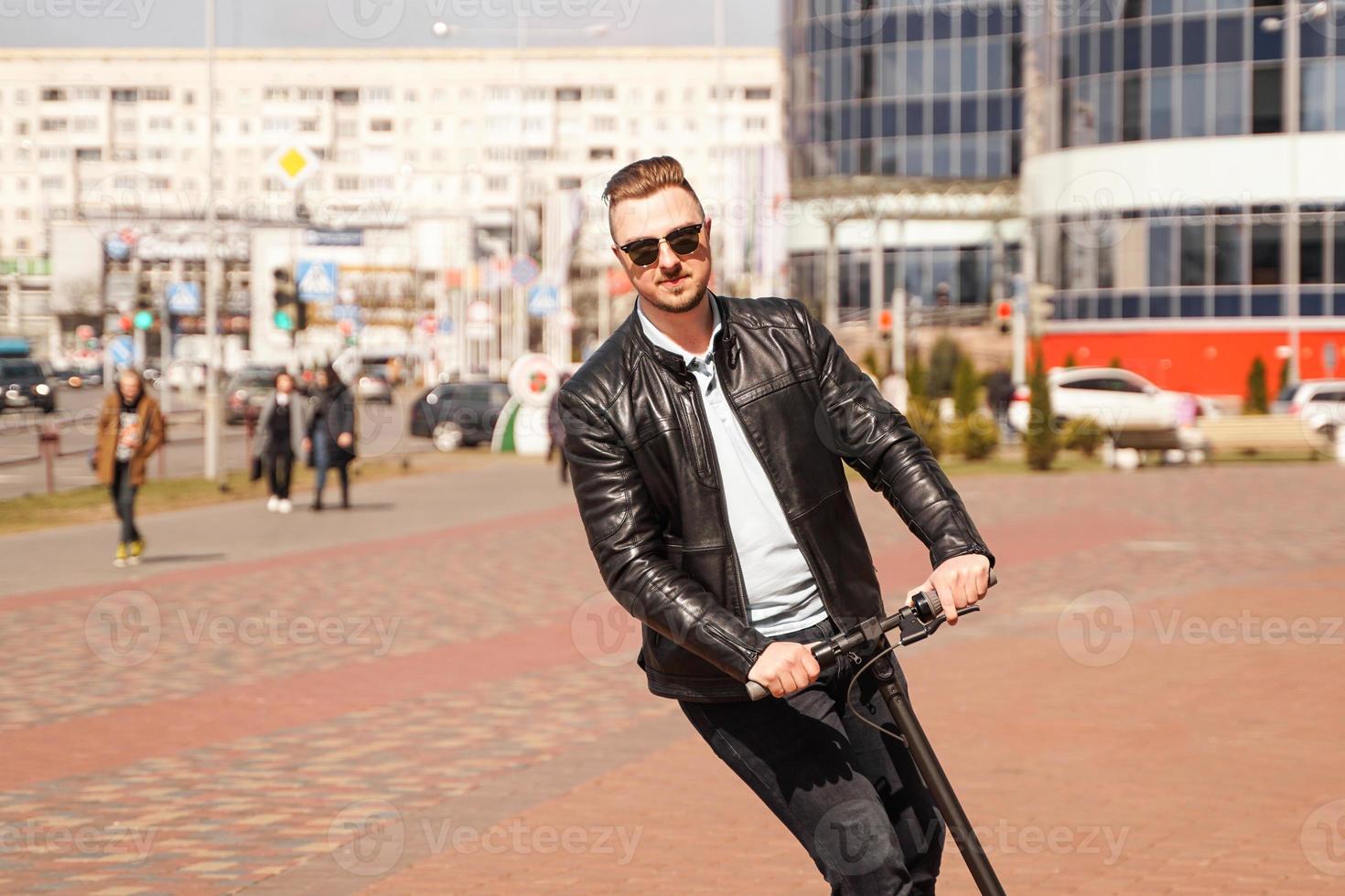 moderne man rijdt op een elektrische scooter in de stad foto