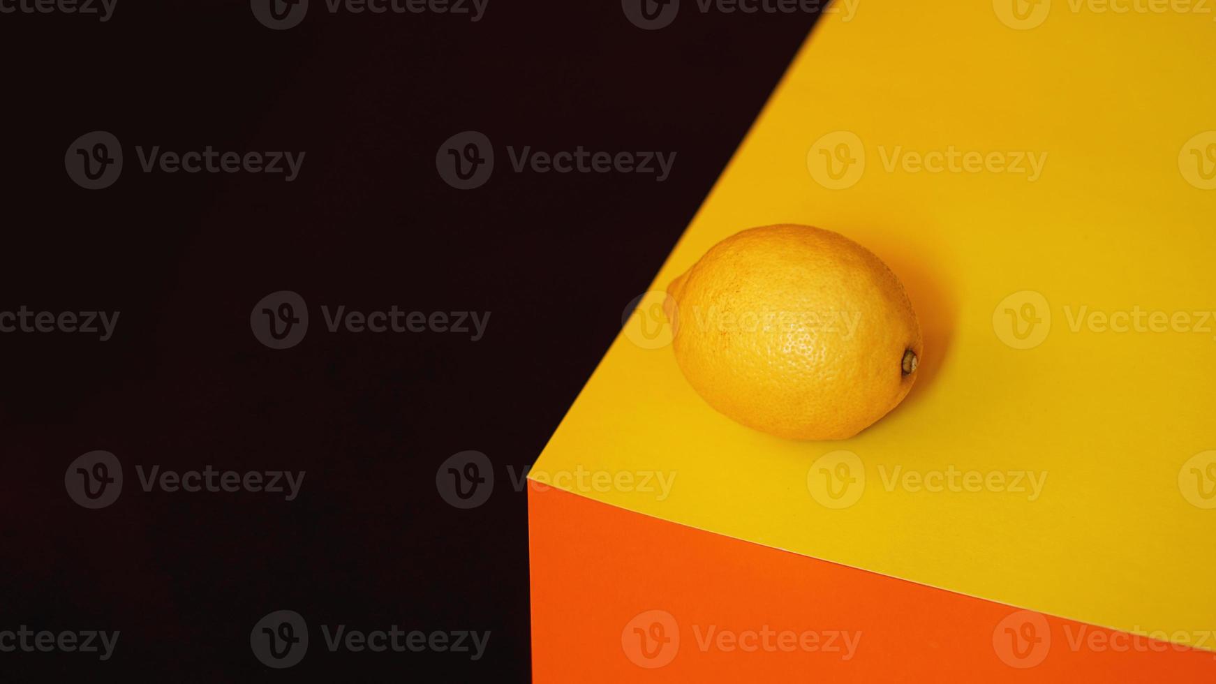 verse gele citroen op zwarte en oranje achtergrond foto