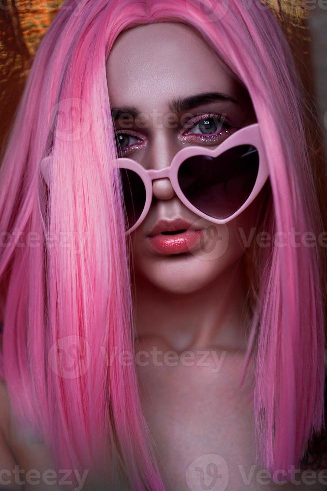 portret van model met roze haar. kleur pruik en trendy bril foto