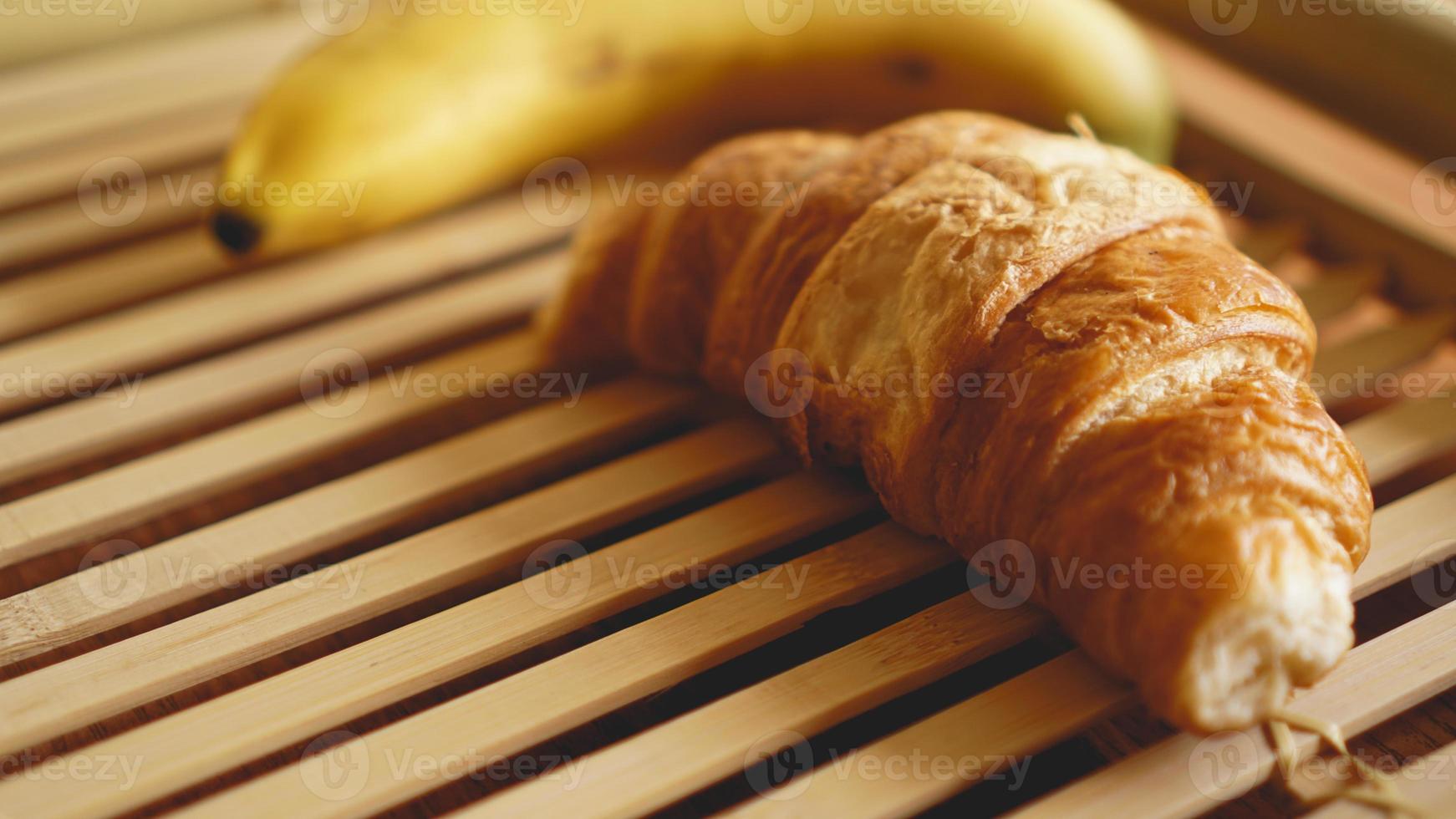 banaan en croissant op rustieke houten achtergrond foto