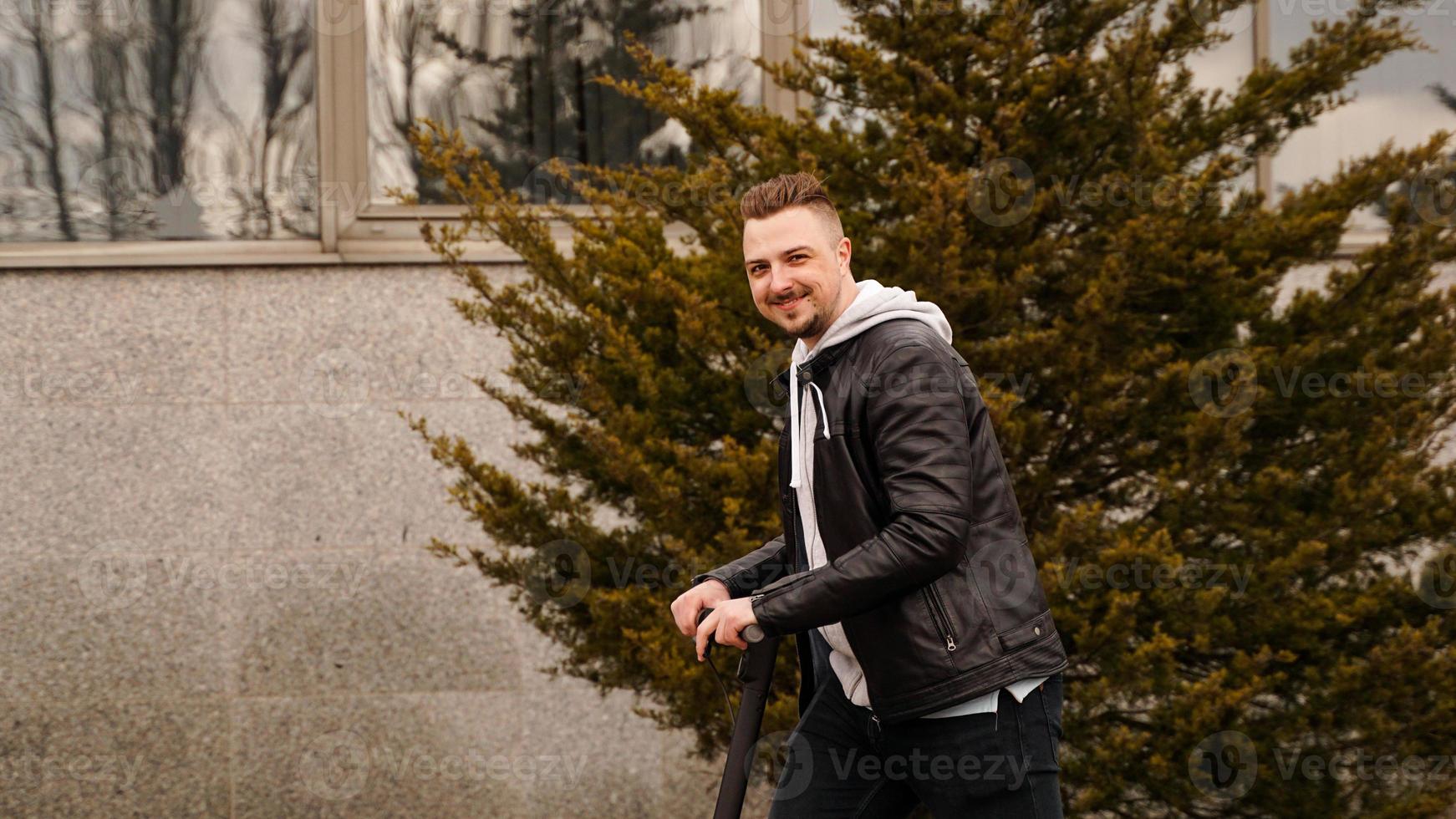 moderne man rijdt op een elektrische scooter in de stad foto