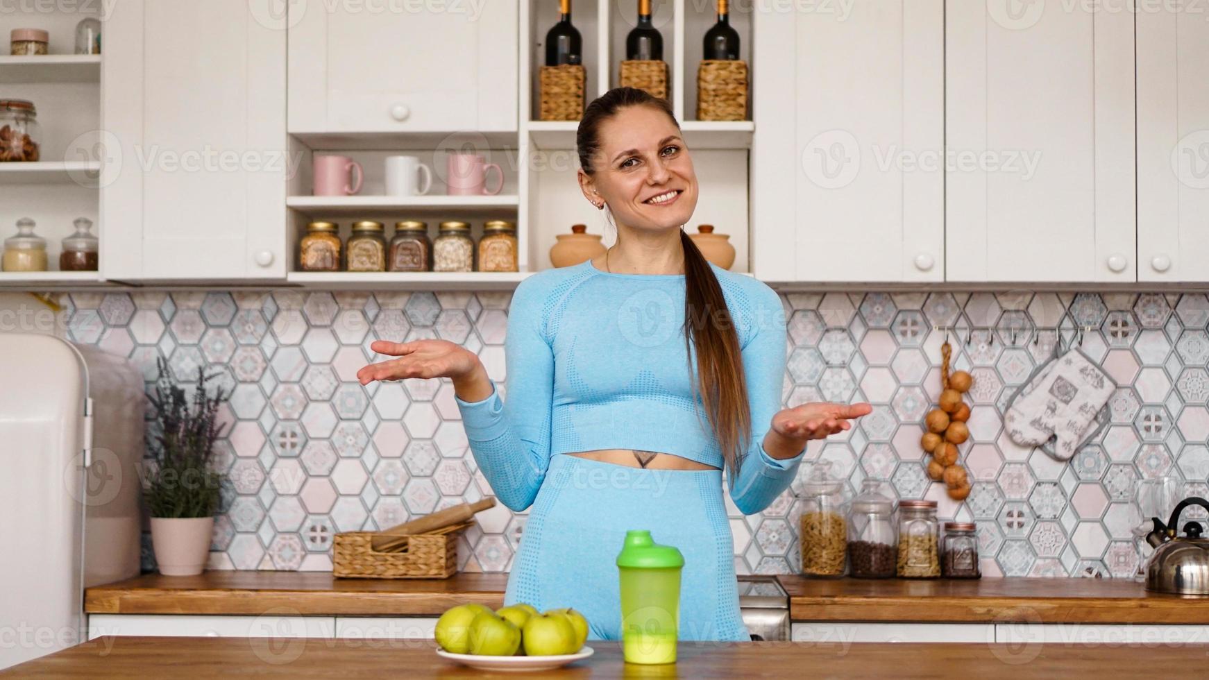 atletische vrouw praat over gezond eten in de keuken en lacht foto