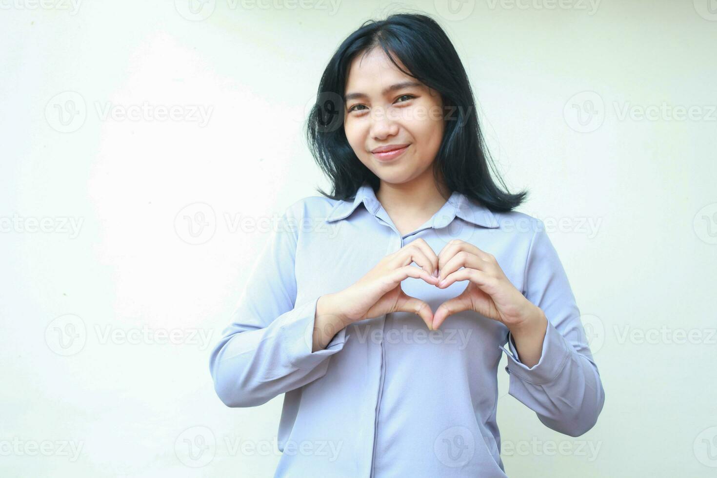 gelukkig Aziatisch jong bedrijf vrouw maken hart vorm liefde teken voelt romantisch, uitdrukken inschrijving gevoel, slijtage formeel overhemd geïsoleerd Aan wit achtergrond foto