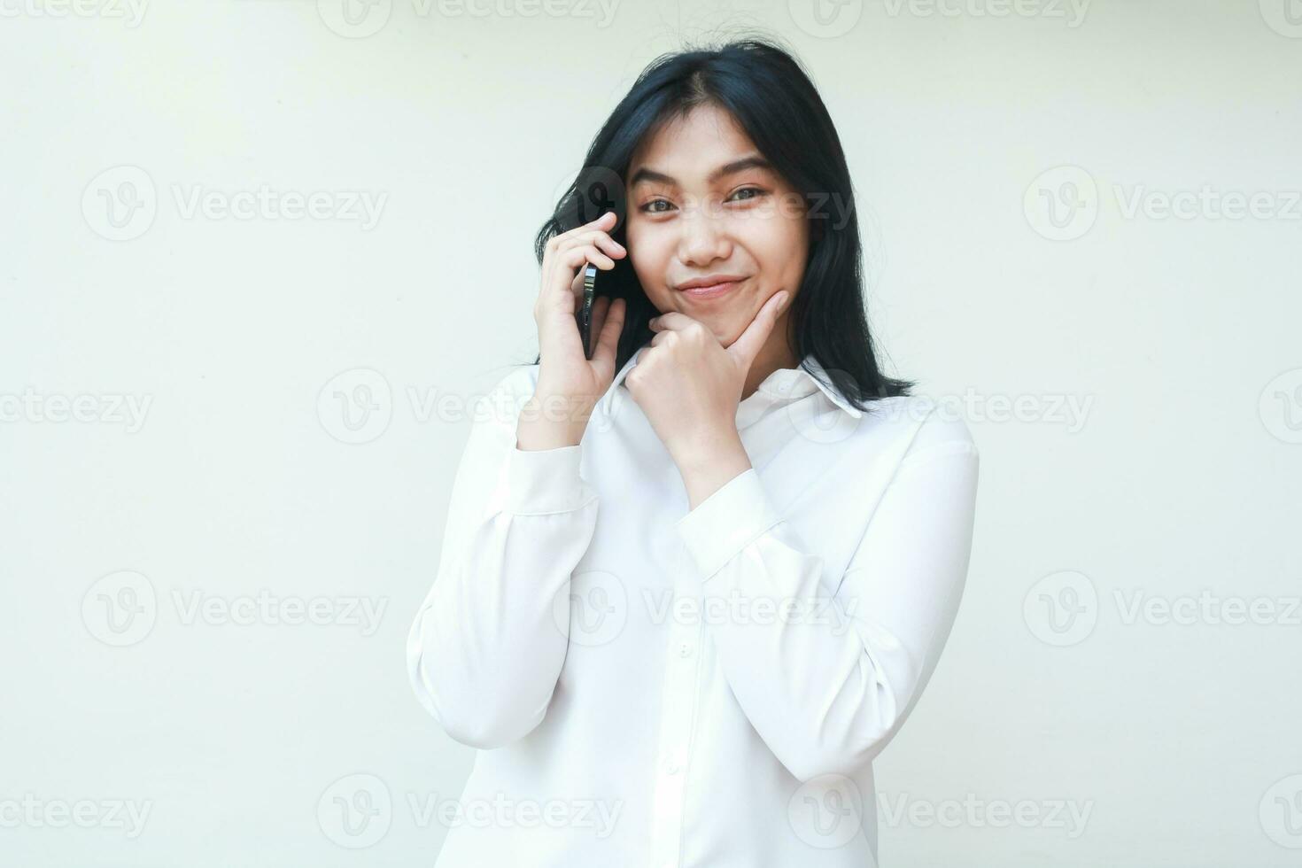 beeld van attent mooi Aziatisch bedrijf vrouw pratend Aan smartphone met handen Aan kin denken en overwegen Product uitverkoop aanbod vervelend wit pak overhemd formeel staand geïsoleerd foto
