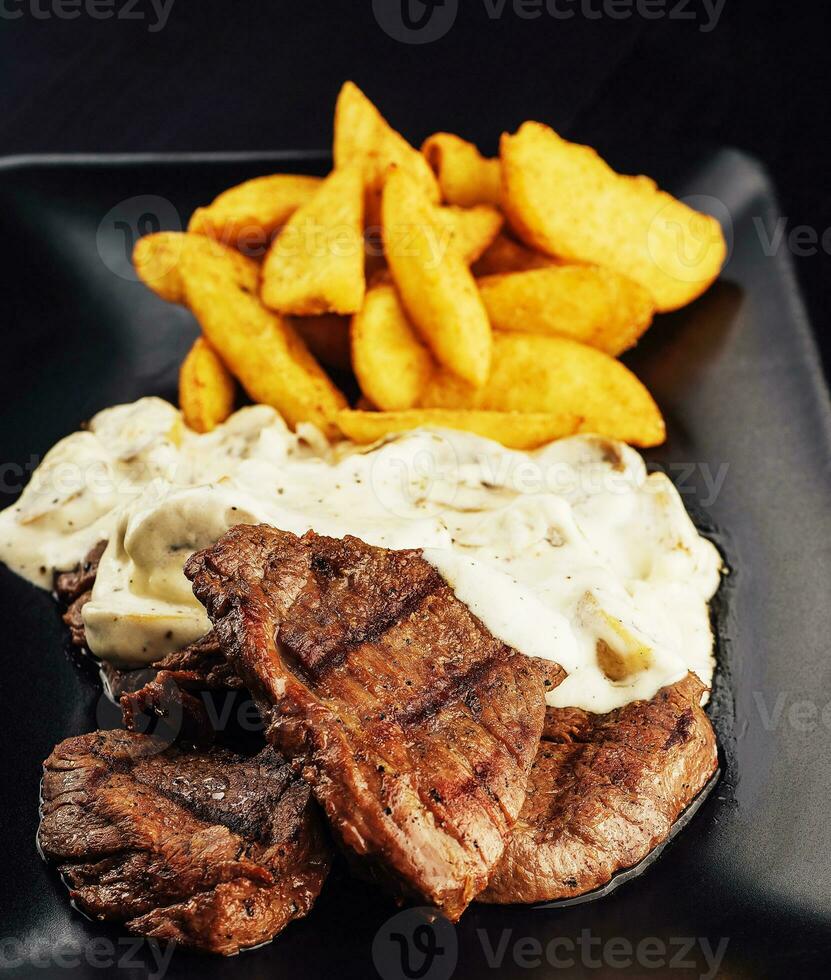 gegrild rundvlees steaks met paddestoel saus en Frans Patat foto