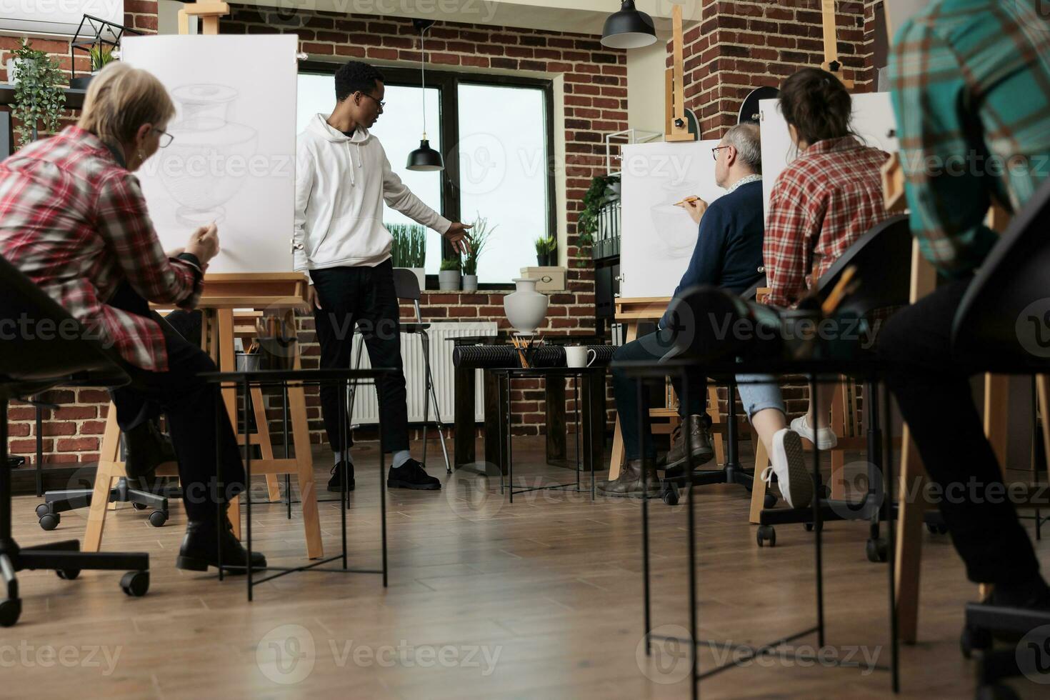 groep van mensen tekening met potloden Aan canvas, Bijwonen kunst klas. Afrikaanse Amerikaans vent leraar staand in klas tonen nog steeds leven object, uitleggen hoe naar trek vormen en proporties foto