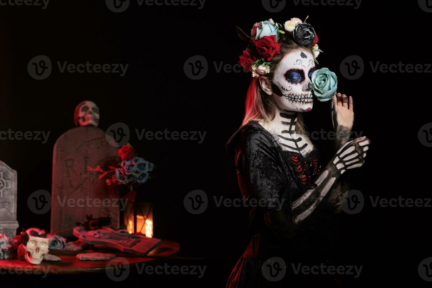 vrouw model- met suiker schedel maken omhoog en blauw rozen gekleed in zwart kostuum van dood net zo de kerstman muerte. dag van de dood lichaam kunst naar vieren Mexicaans ritueel Aan halloween, cultuur mythe. foto