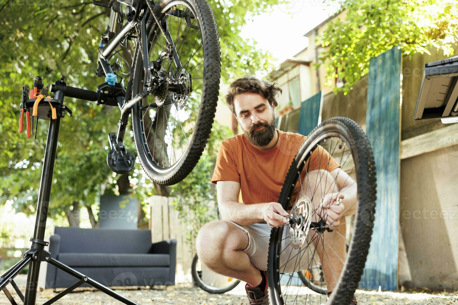 een toegewijd sportief Kaukasisch mannetje het uitvoeren van fiets onderhoud Aan zijn eigen buitenshuis zomer werkzaamheid. jong enthousiast Mens aan het doen jaar- onderhoud en repareren van modern fiets. foto