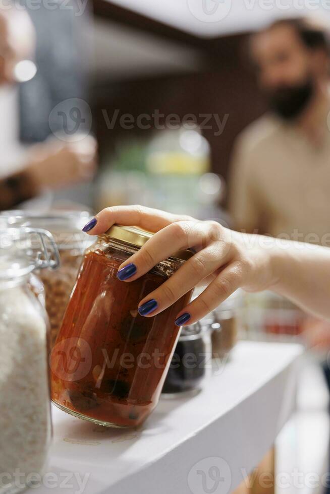 dichtbij omhoog schot van cliënt Bij nul verspilling supermarkt uitchecken teller buying biologisch bio voedsel. eco vriendelijk lokaal buurt op te slaan cliënt inkoop conserveermiddelen vrij groente stoofpot in pot foto