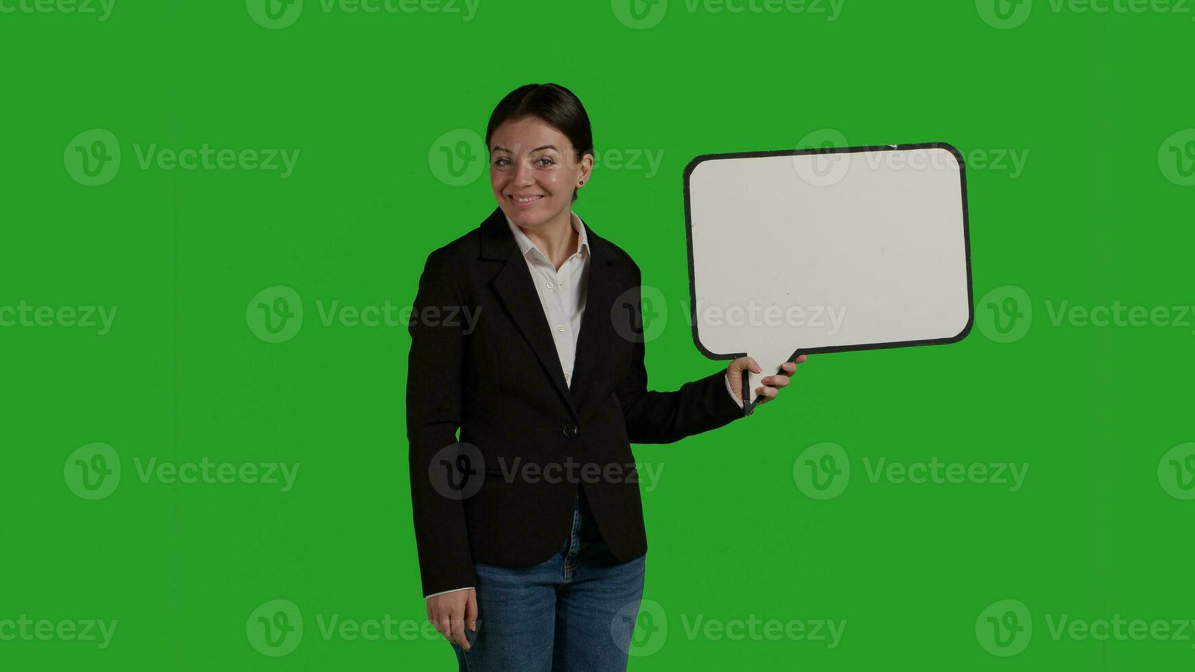 voorkant visie van bedrijf manager Holding toespraak bubbel Aan camera, tonen geïsoleerd karton icoon over- groene scherm achtergrond. vrouw in pak gebruik makend van karton bord met blanco copyspace in studio. foto