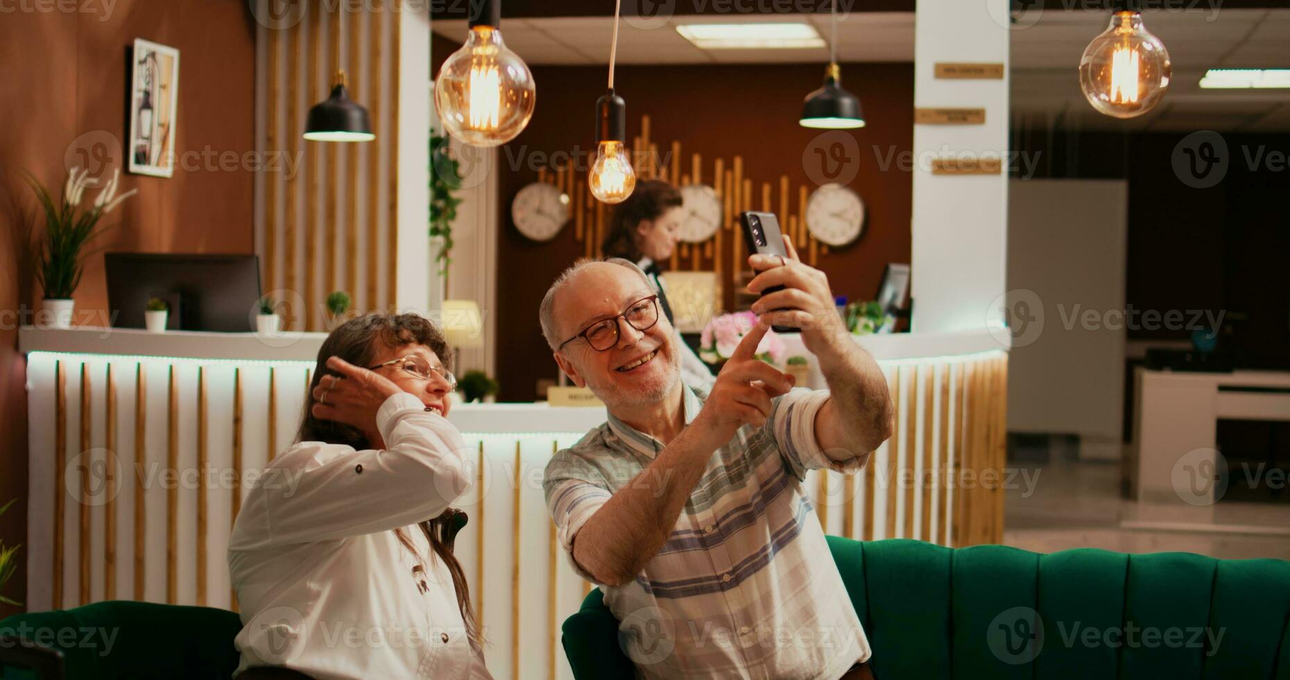 ouderen mensen nemen foto's in lobby, opname allemaal activiteiten Aan pensioen vakantie Buitenland. oud man en vrouw nemen afbeeldingen Aan smartphone, maken herinneringen voor familie leden. foto