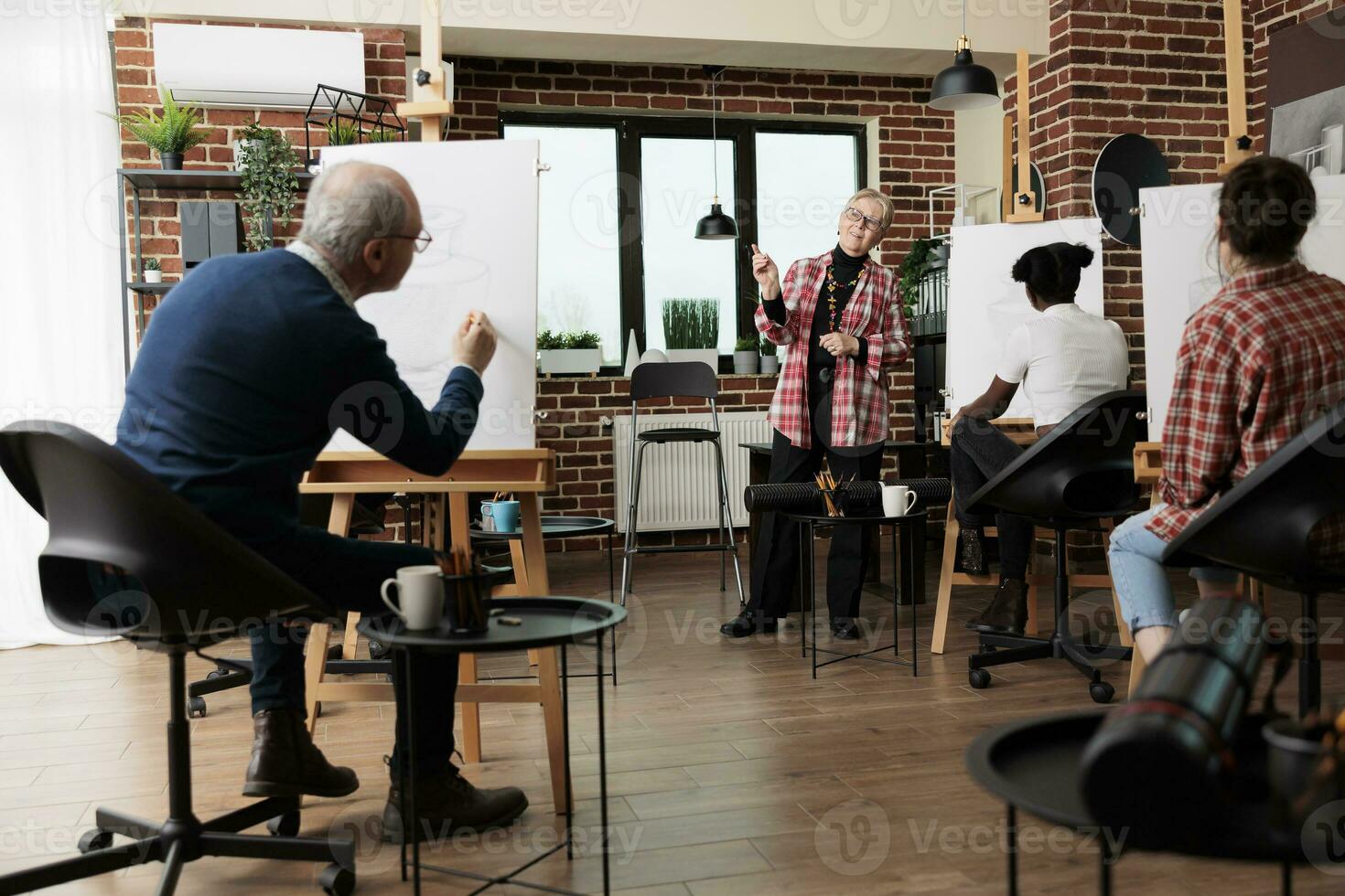 groep van verschillend verschillend oud studenten aan het leren tekening met positief senior vrouw leraar Bij groep kunst klas. volwassen vrouw artiest onderwijs hoe naar trek met potlood, gedurende les foto