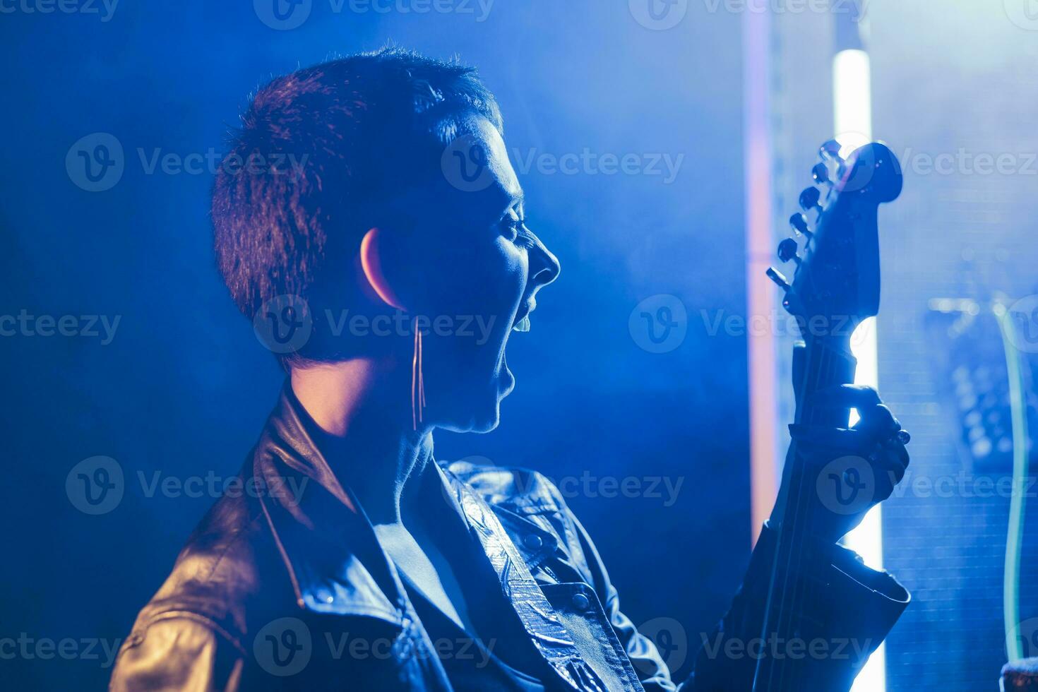 musicus performer Holding elektrisch gitaar spelen zwaar metaal lied in studio voorbereidingen treffen rots prestatie voor grunge concert. mooi gitarist werken Bij punk- album, controle instrument geluid foto