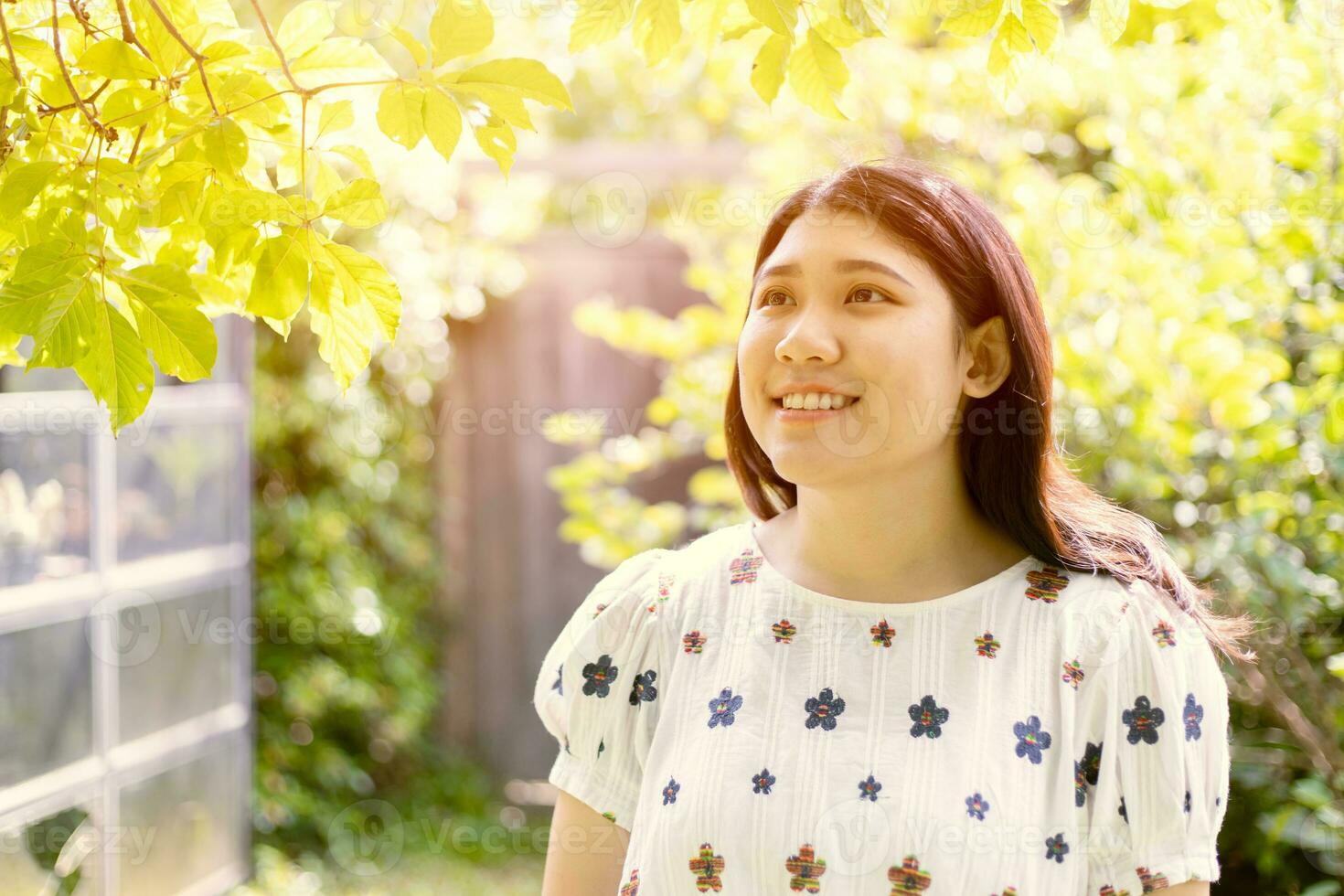 geluk vrouw jong tiener vrije tijd glimlachen in de tuin met groen boom vers milieu lucht ecologie in achtertuin foto