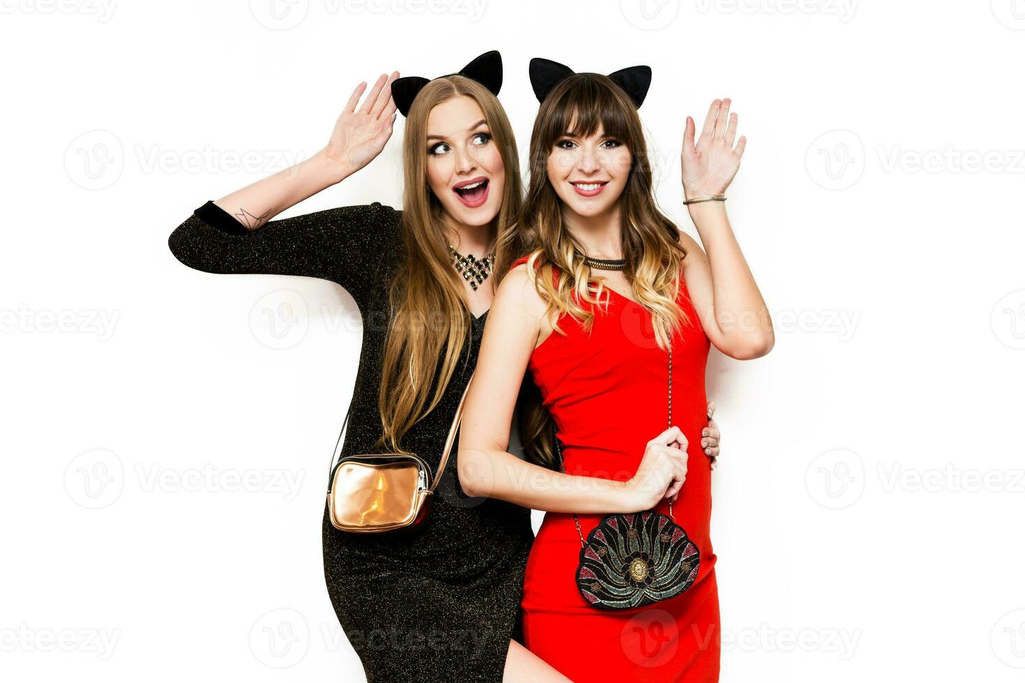 twee mooi Dames in kat carnaval oren , avond jurk hebben pret Aan wit isoleren achtergrond. vrienden vieren nieuw jaar of verjaardag feest. foto