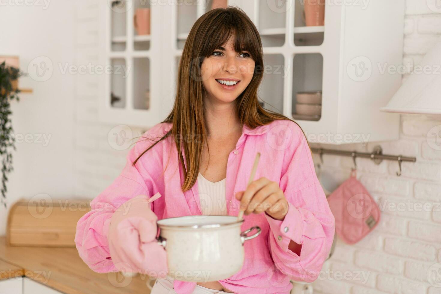 gelukkig huisvrouw voorbereiding avondeten in modern keuken. foto