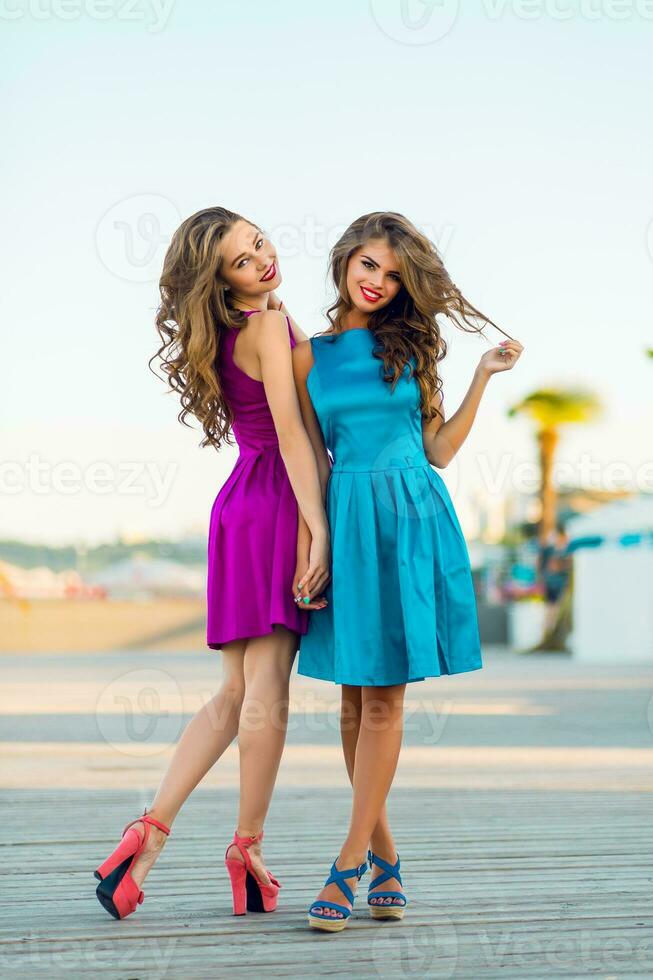twee mooi elegant Dames in avond cocktail jurken wandelen langs de promenade . genieten van tijd samen en hebben plezier. foto