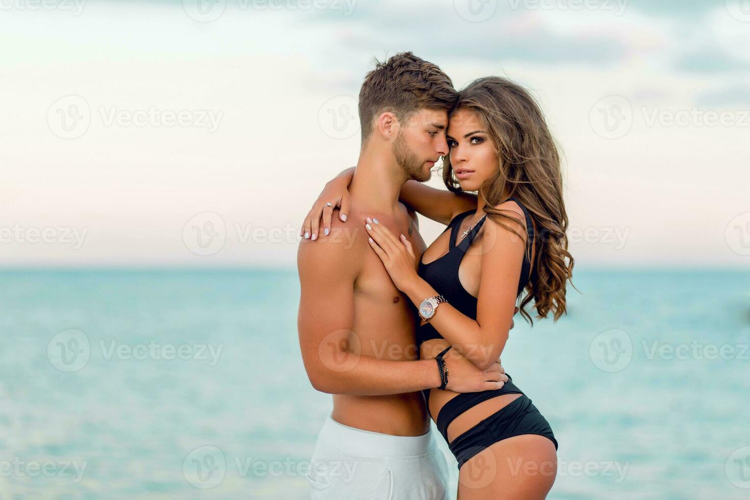 paar in liefde hebben pret Aan verbazingwekkend paradijs tropisch strand , vervelend elegant zwempak .sexy jong model- en haar knap Mens genieten van zomer tijd . foto