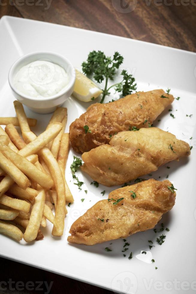 Britse traditionele fish and chips-maaltijd op klassieke houten tafel foto