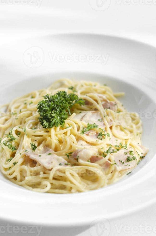 spaghetti carbonara italiaanse pastaschotel op witte tafel achtergrond foto