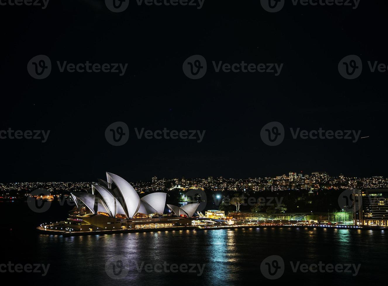 Sydney City Harbor met de skyline van het operagebouw 's nachts in Australië foto