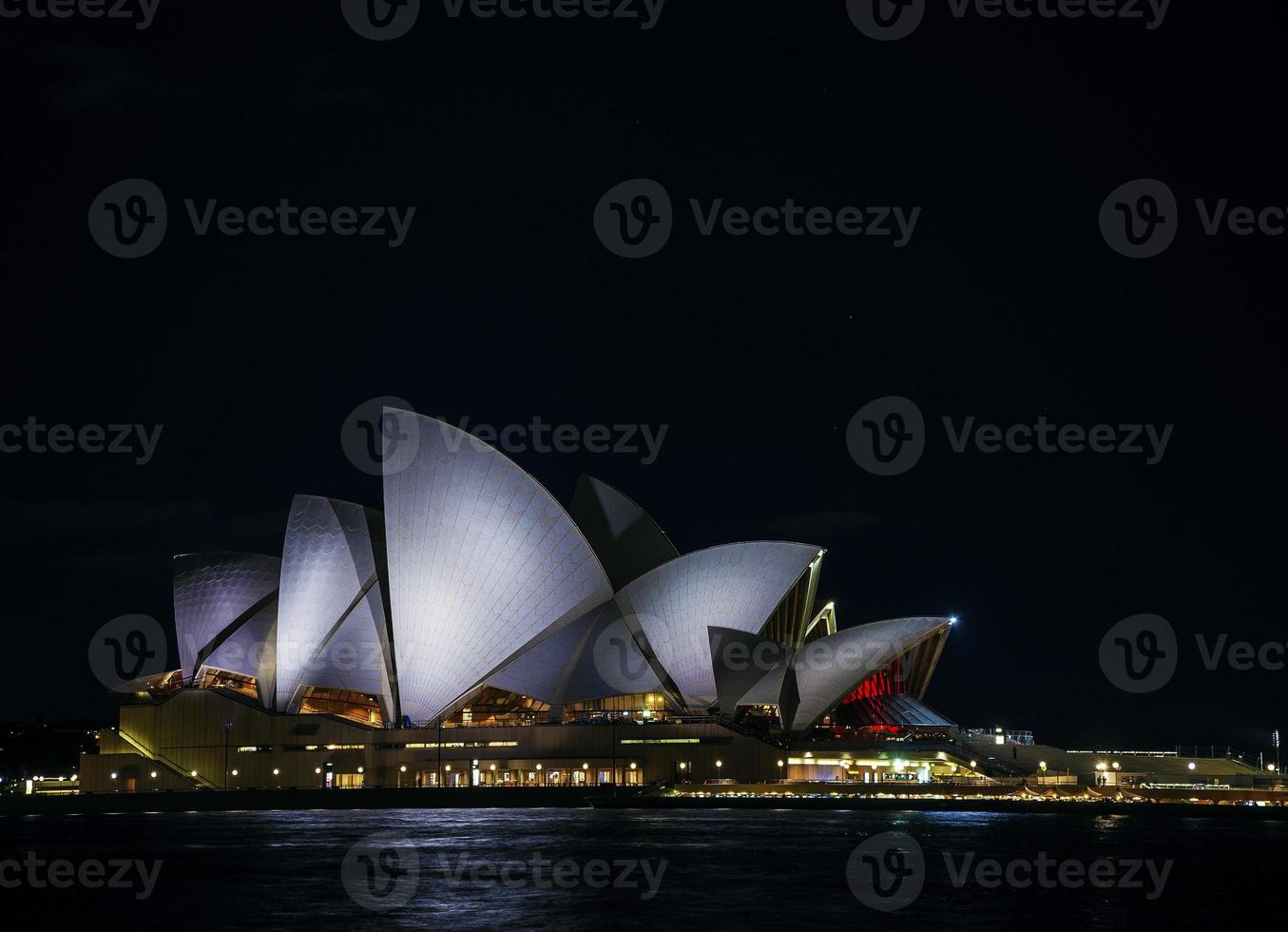 Sydney City Harbor met de skyline van het operagebouw 's nachts in Australië foto