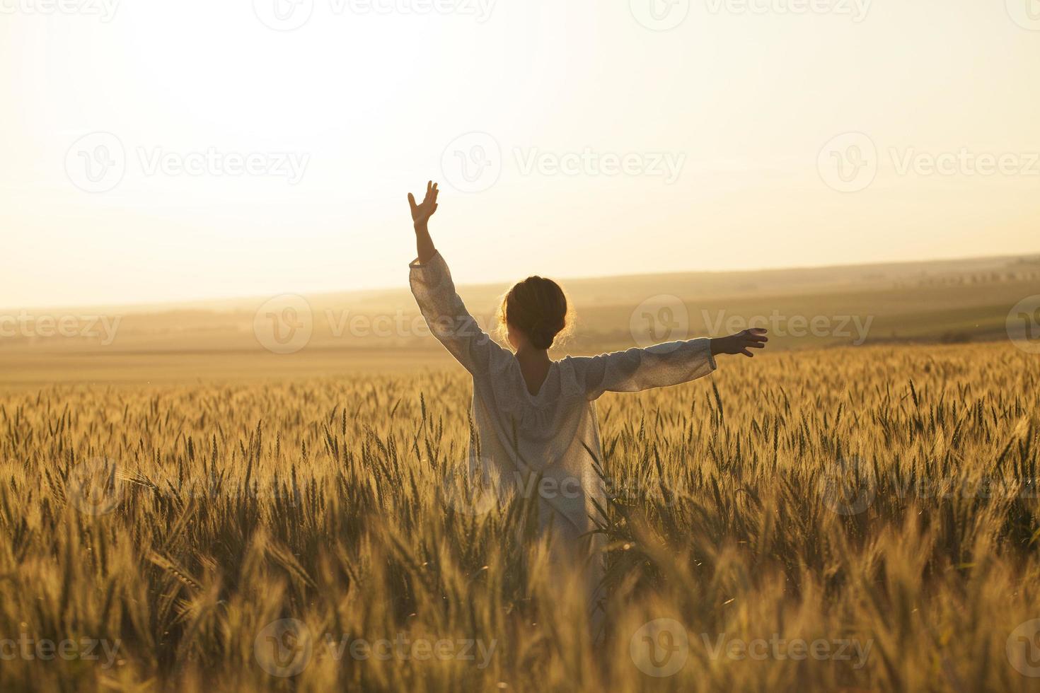 meisje in een jurk in het midden van een veld met rijpe rogge foto