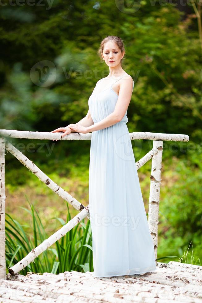 jonge vrouw in een lange blauwe jurk foto