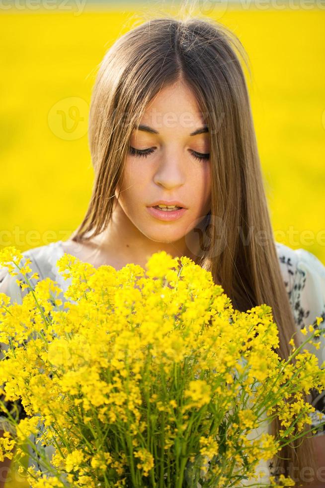 jonge vrouw met een boeket gele wilde bloemen foto