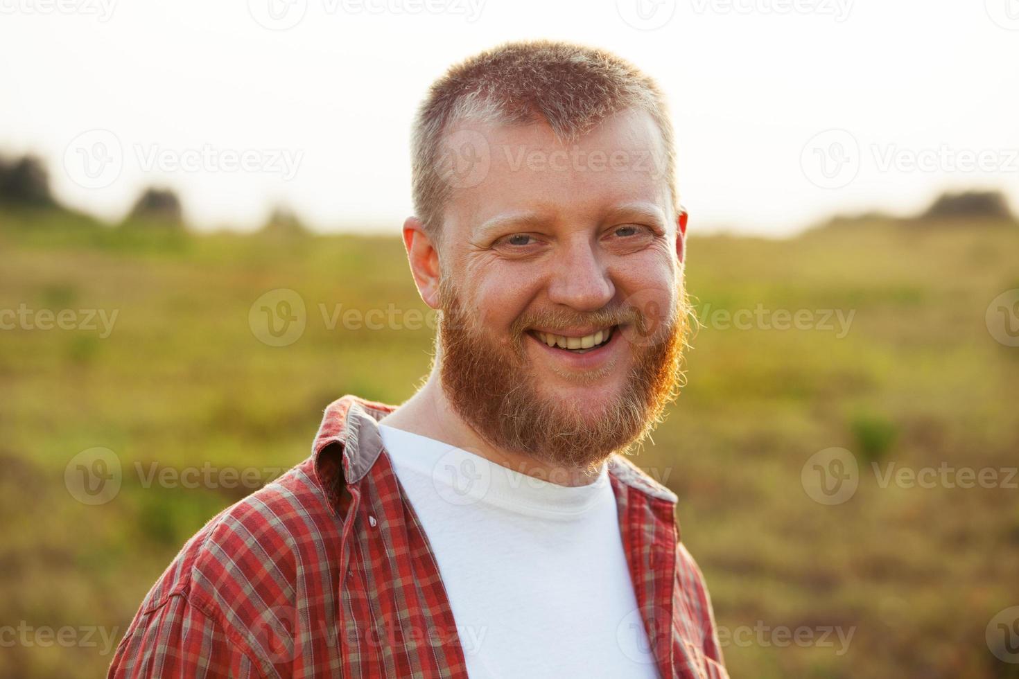 vrolijke, bebaarde man in een rood shirt foto