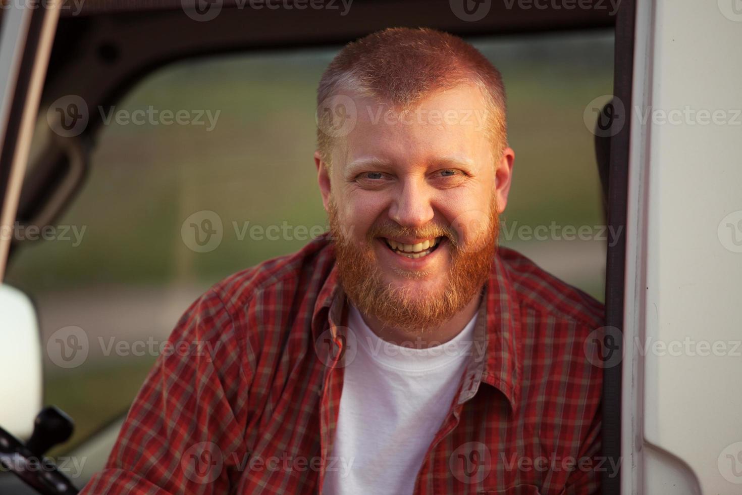 vrolijke man met rode baard in een geruit overhemd foto