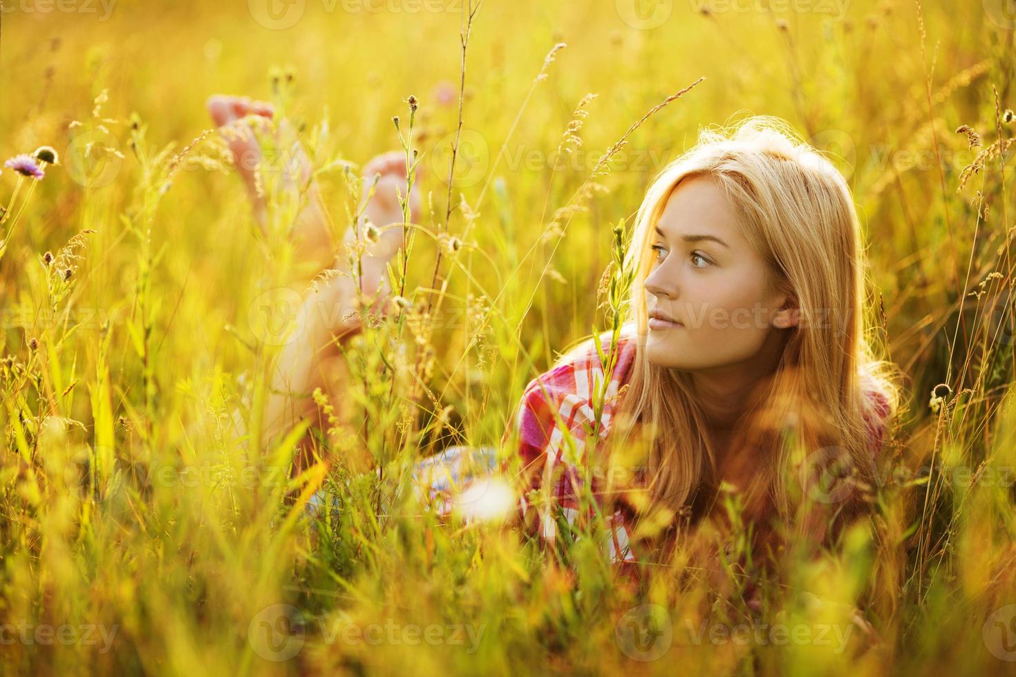 gelukkig meisje in een veld van gras en bloemen foto