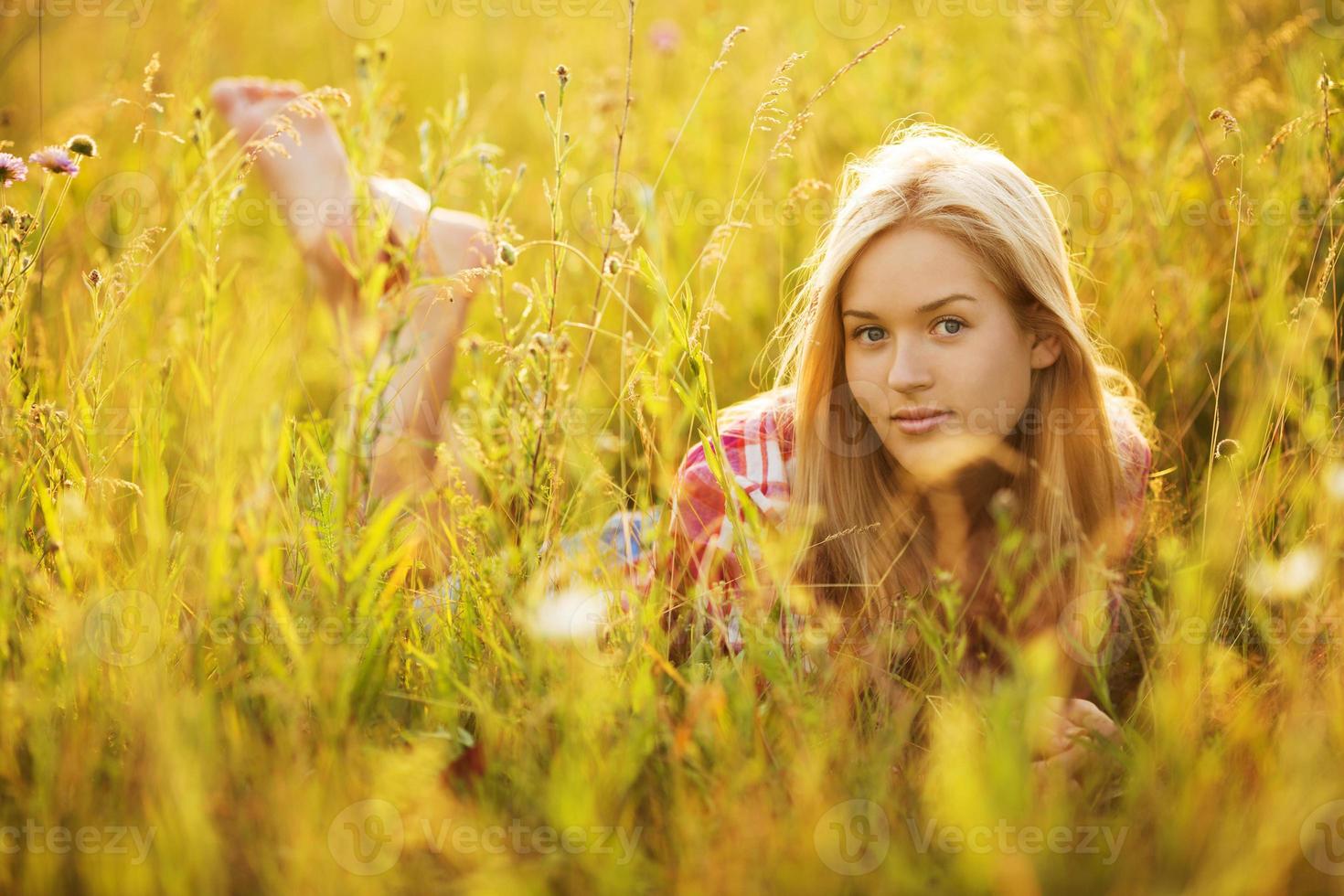 gelukkig meisje liggend tussen de wilde bloemen foto