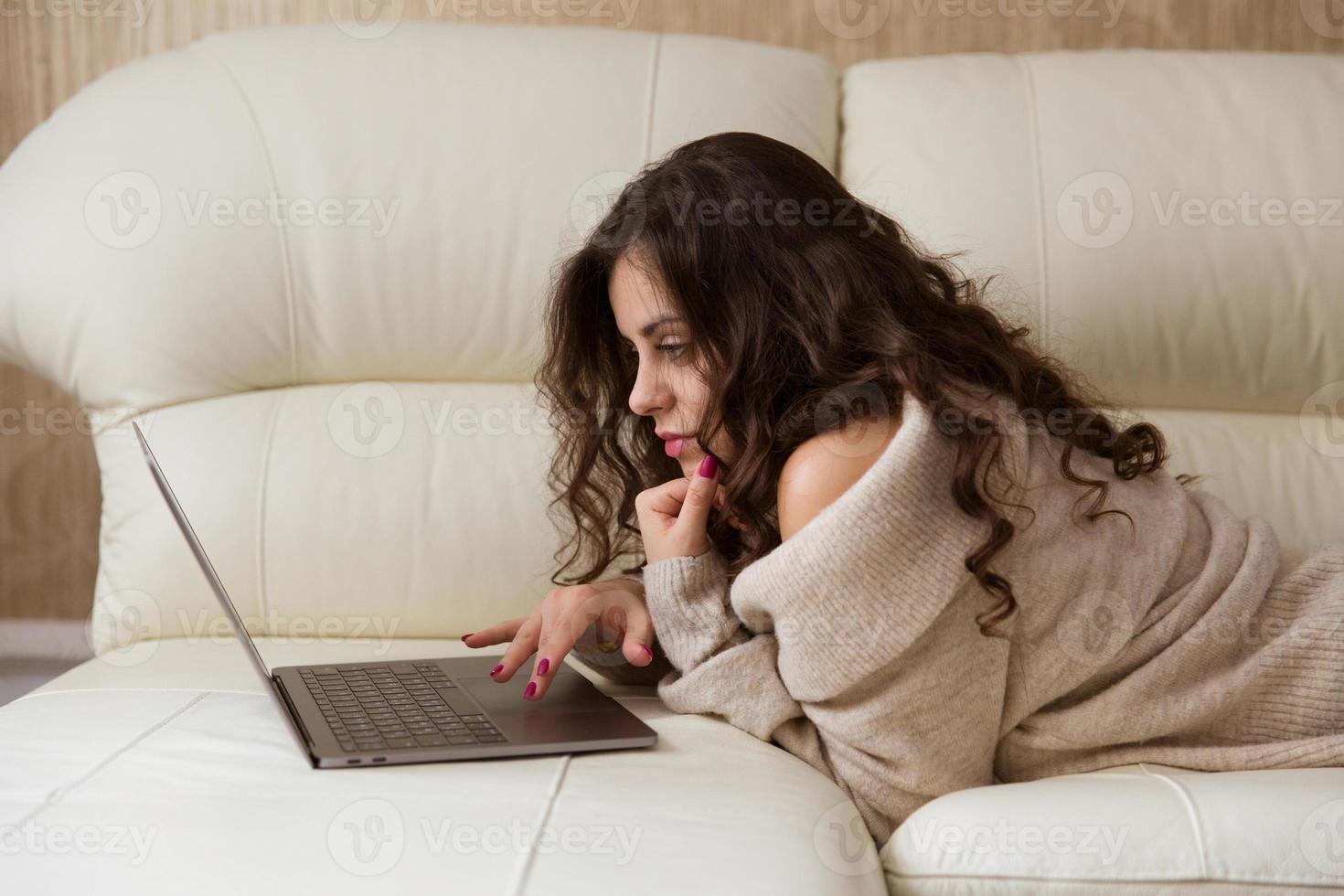 vrouw ligt met een kleine laptop foto