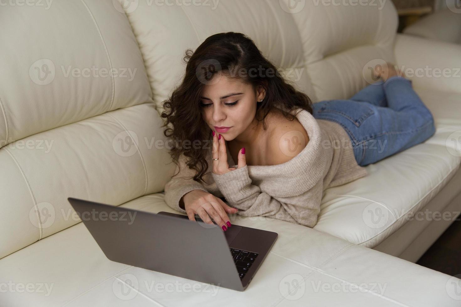 meisje liggend op de bank met een laptop foto