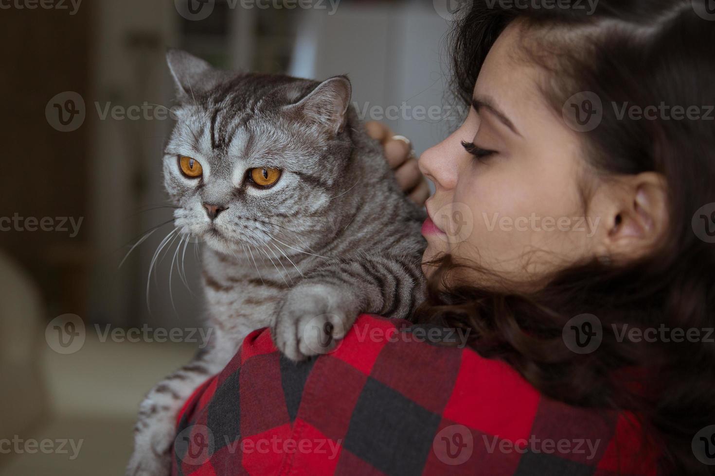 grijze kat op de schouder van een jonge vrouw foto