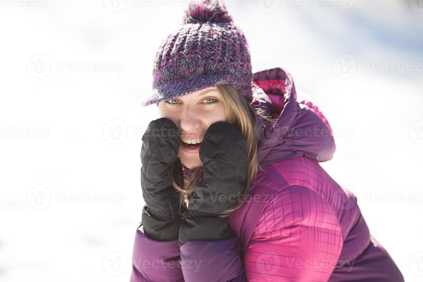 vrolijke vrouw in bordeauxrood jasje in de winter foto