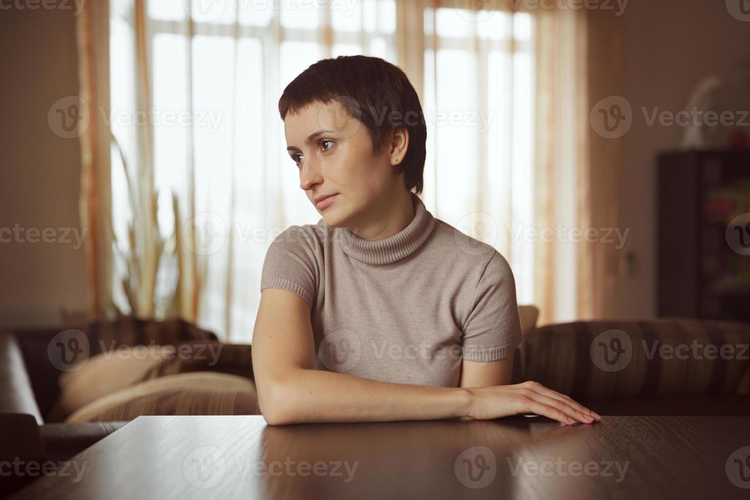 mooie jonge vrouw zittend aan tafel foto