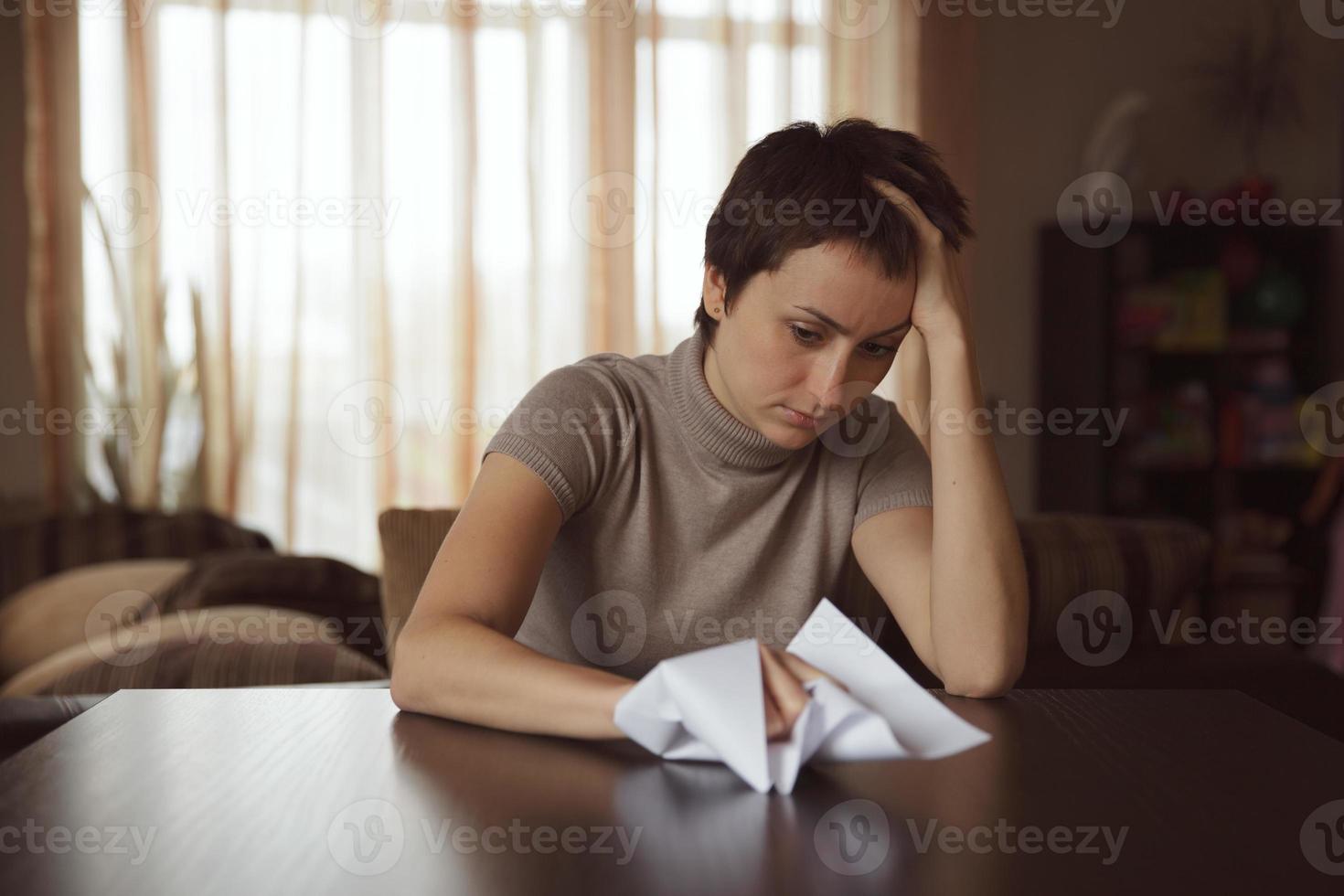 jonge trieste vrouw met een verfrommelde brief foto