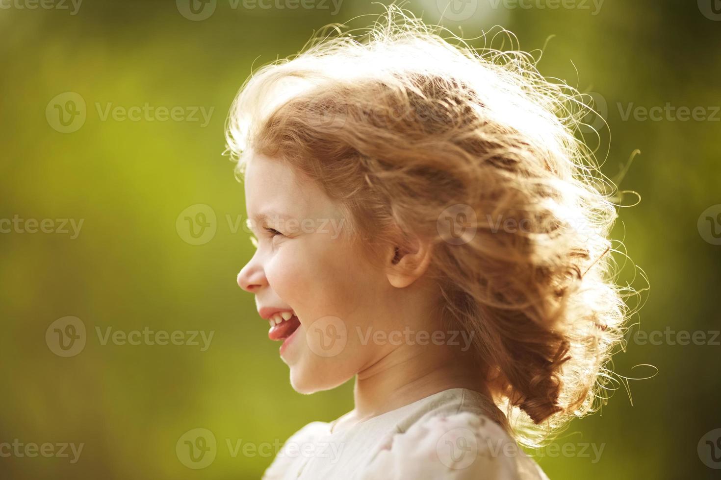 gelukkig klein meisje met verward haar foto