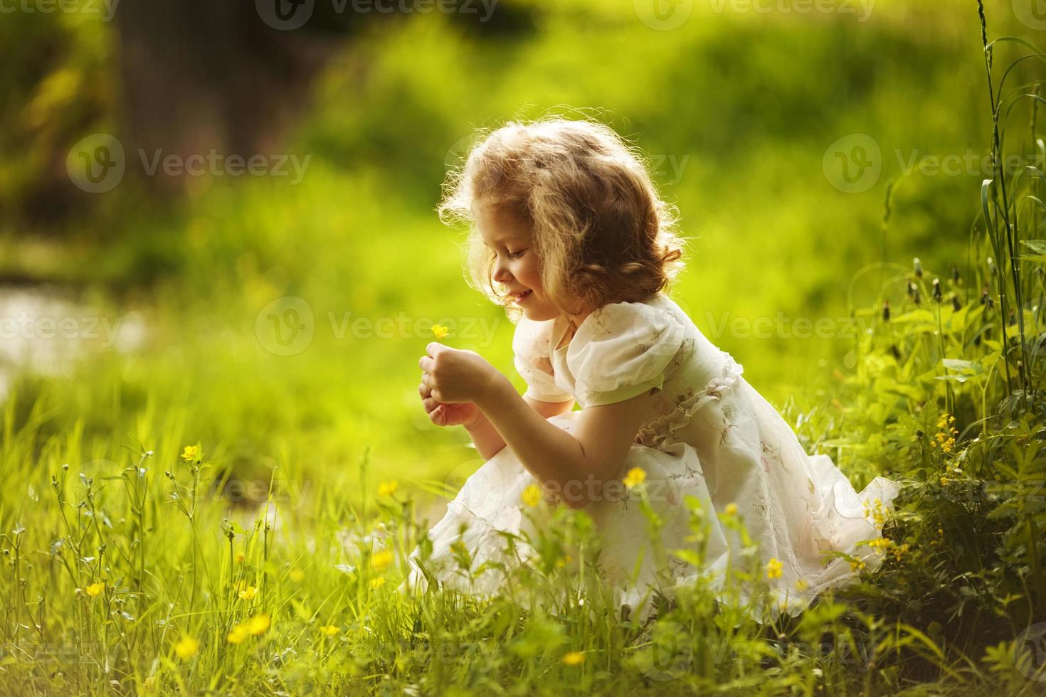 klein blij meisje met een bloem foto