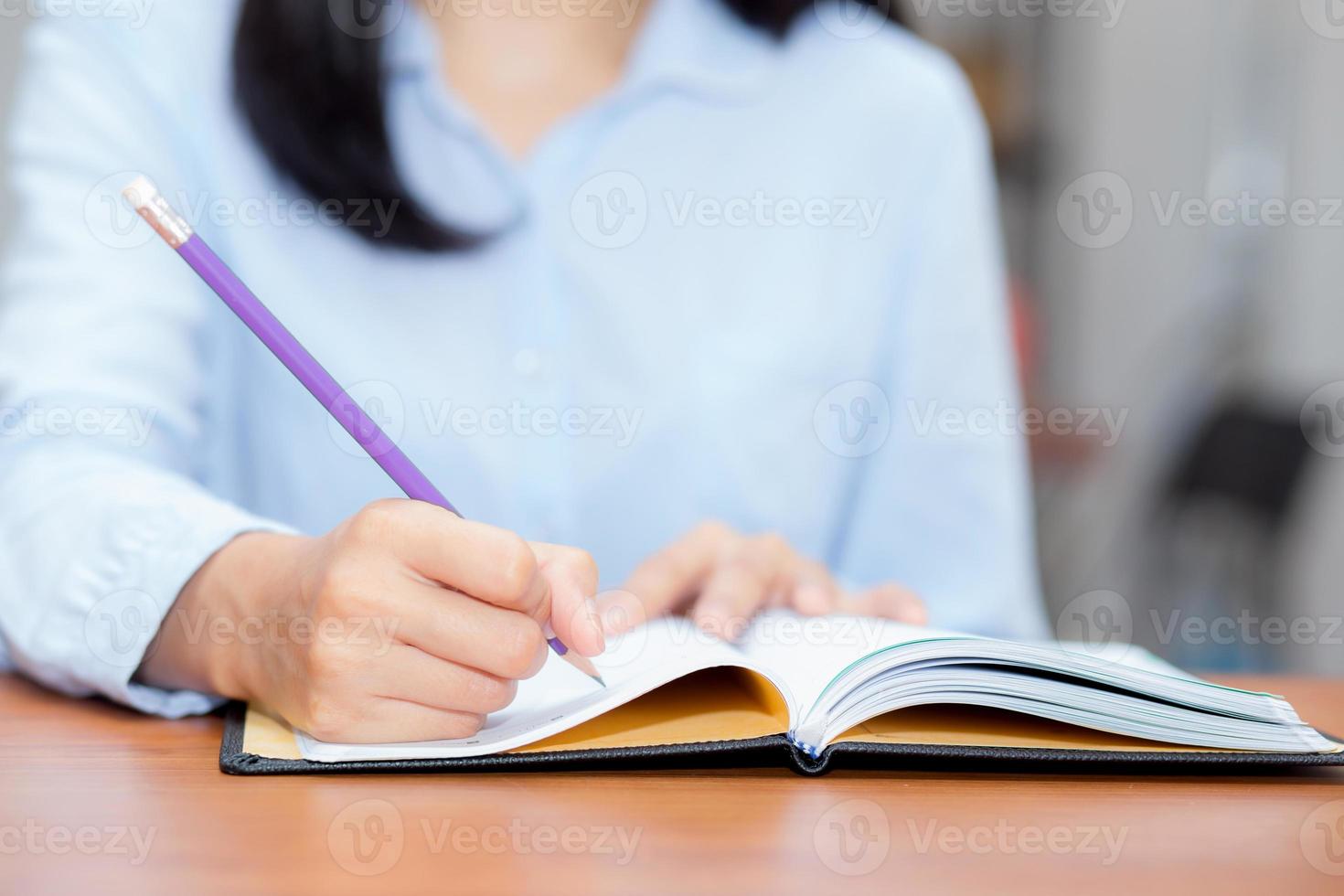 hand van vrouw schrijven op notebook op tafel. foto